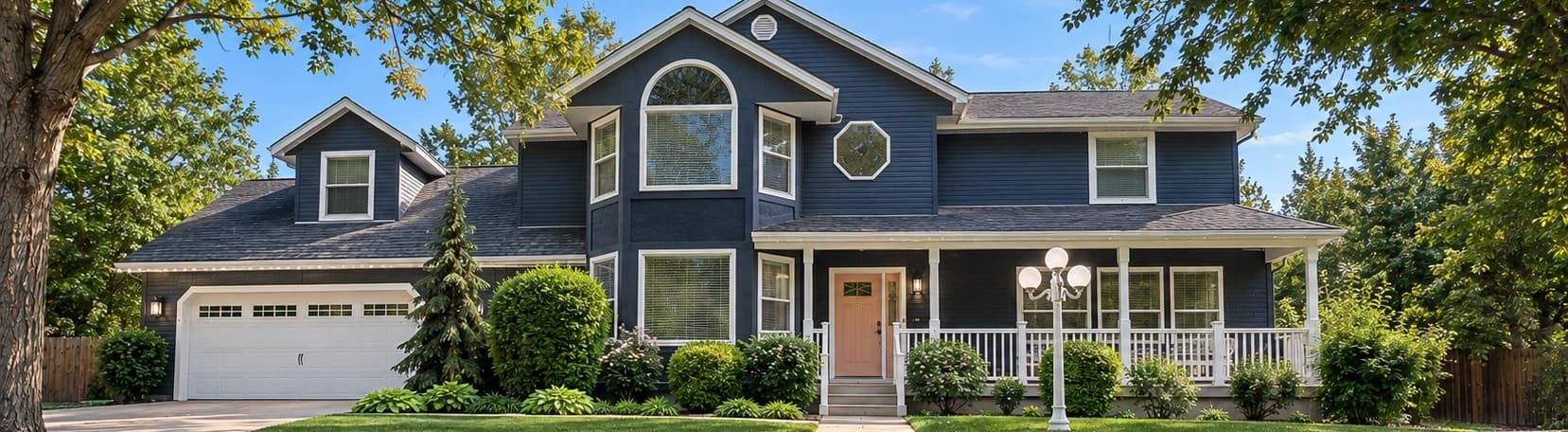 Two-story home with a front porch during the day, with the lighting track blending into the white trim