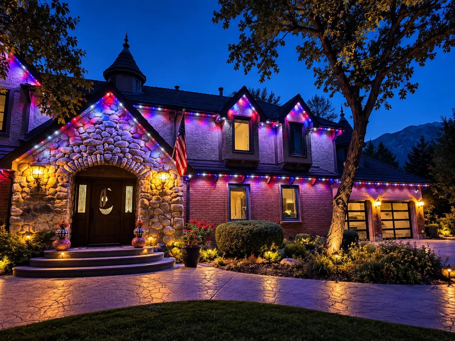 Stone and brick Utah home at dusk with red, white, and blue permanent holiday lights by Ekko Lighting